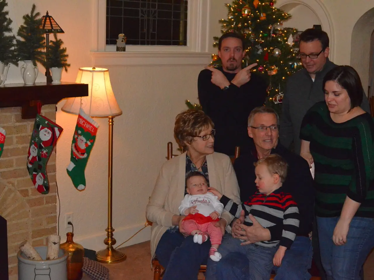 Here we can see few persons. There is a lamp, water tin, banners, flower vases, window, and a...