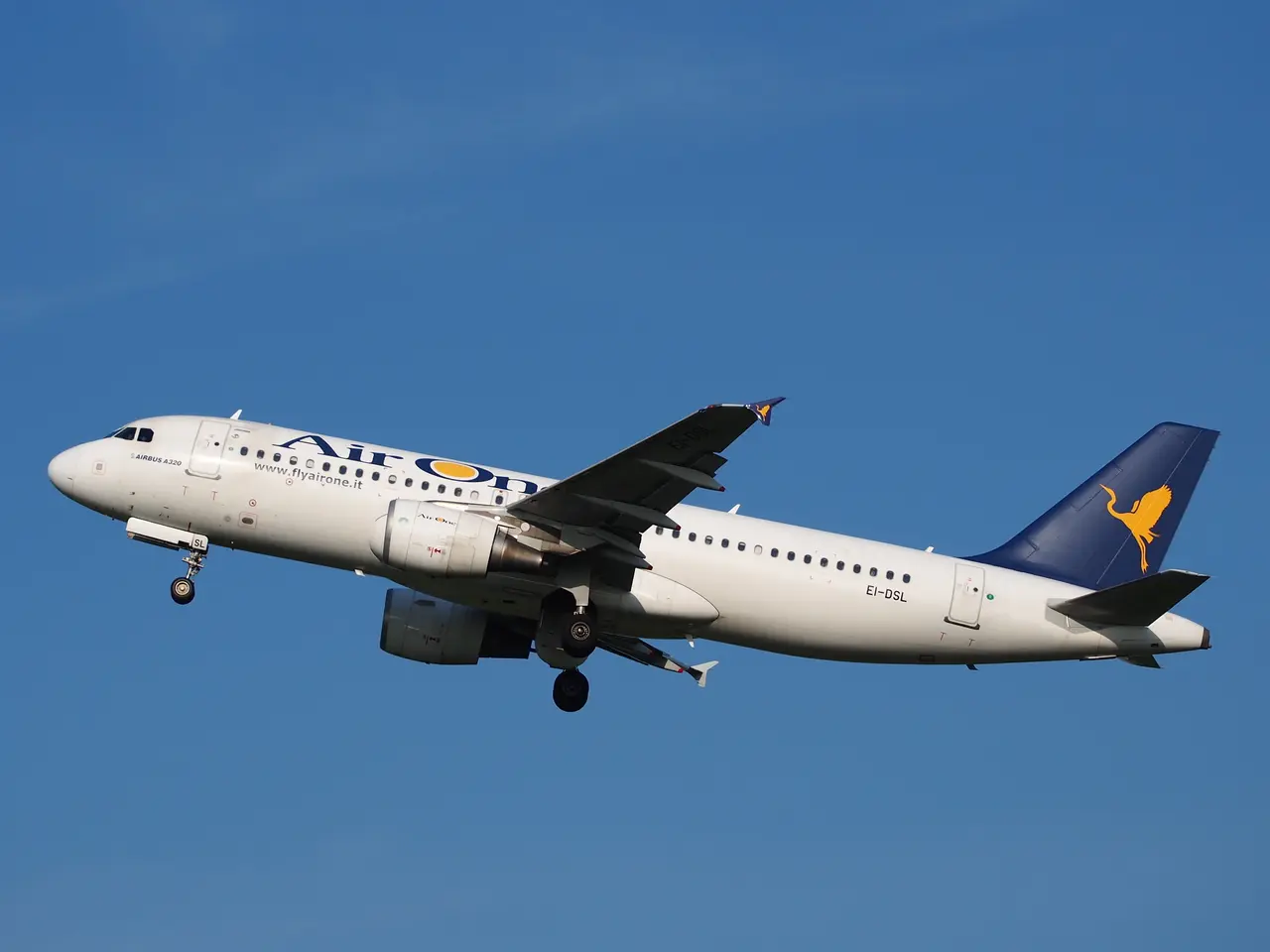 The image shows an Airbus A320-200 of Air France flying in the sky with its landing gear down. The...