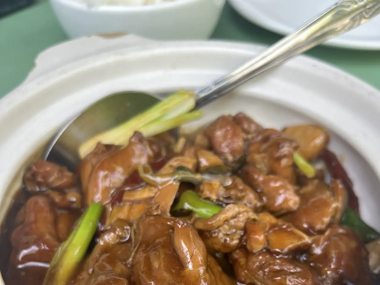 The image shows a table with a bowl filled with teriyaki, a traditional Chinese dish, on top of it....