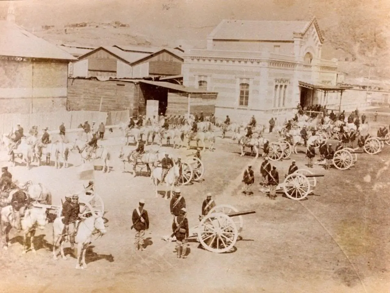 The image shows an old black and white photo of a group of people on horseback in front of a...