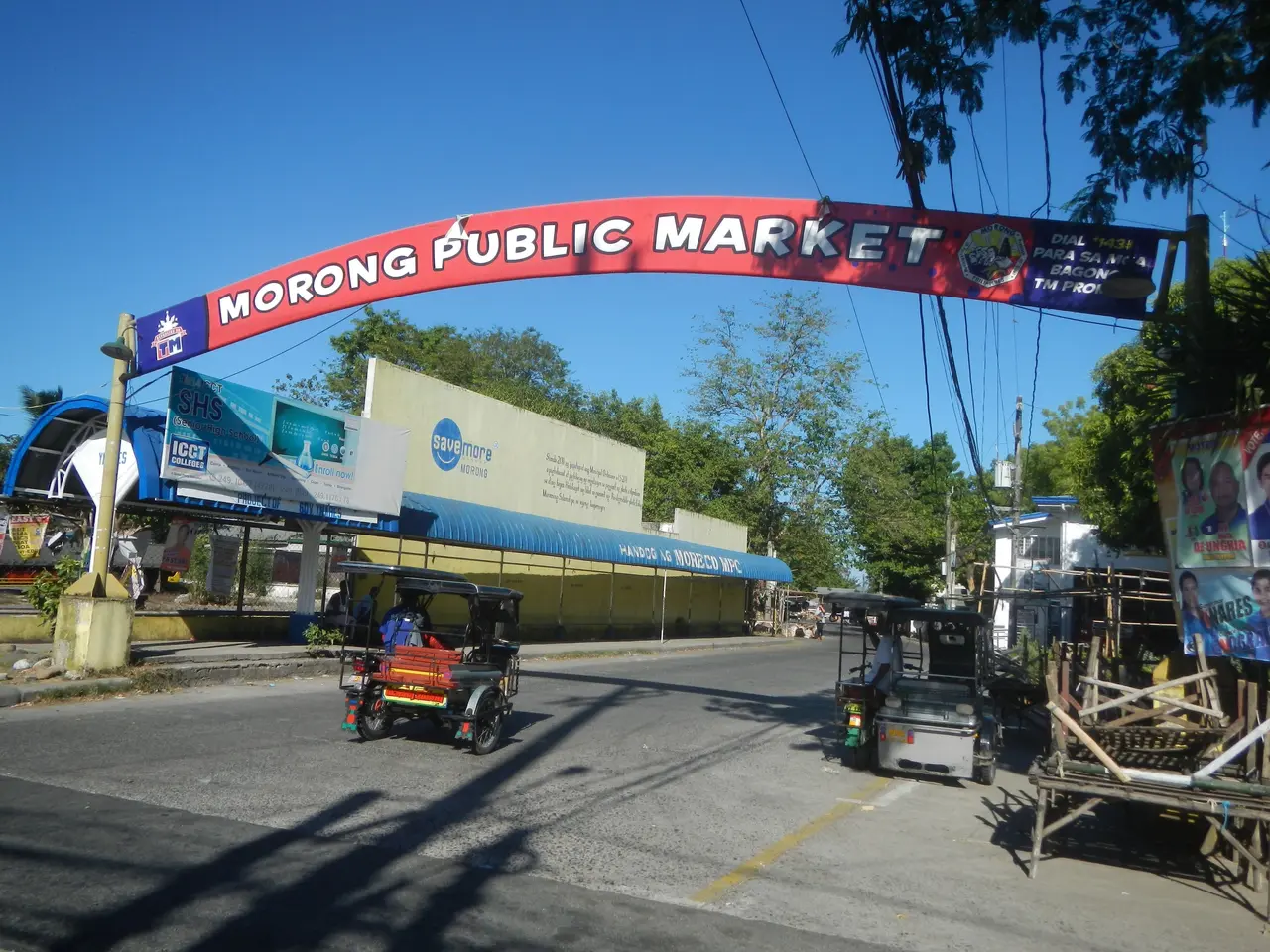 The image shows the entrance to the Morong Public Market in the Philippines, with vehicles on the...