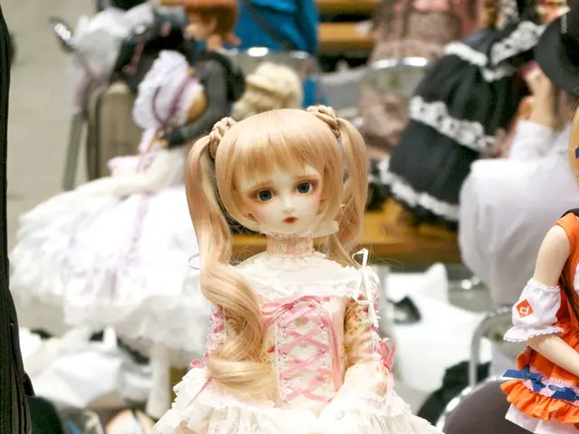 In this image there are dolls, card and objects.