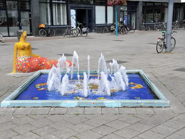 In this picture we can see a fountain with water, statue, bicycles on the ground, poles, basket,...