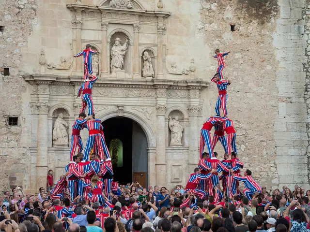 In the foreground of this picture, there are persons performing pyramid and also crowd around them....