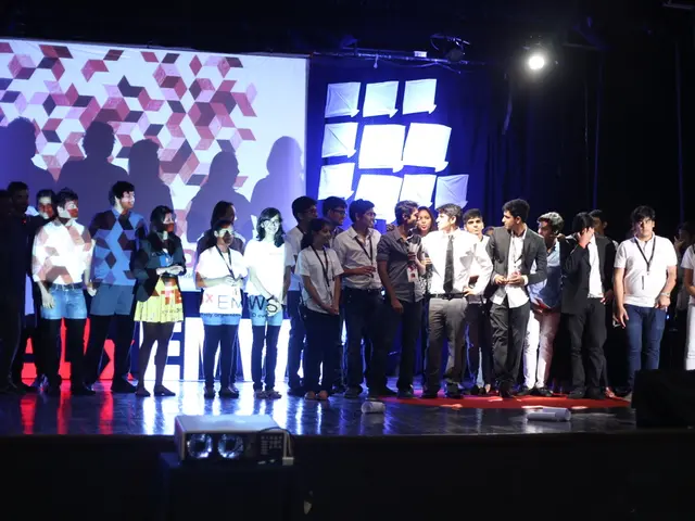 In this picture, we can a group of people standing on the stage and on the stage there are papers....