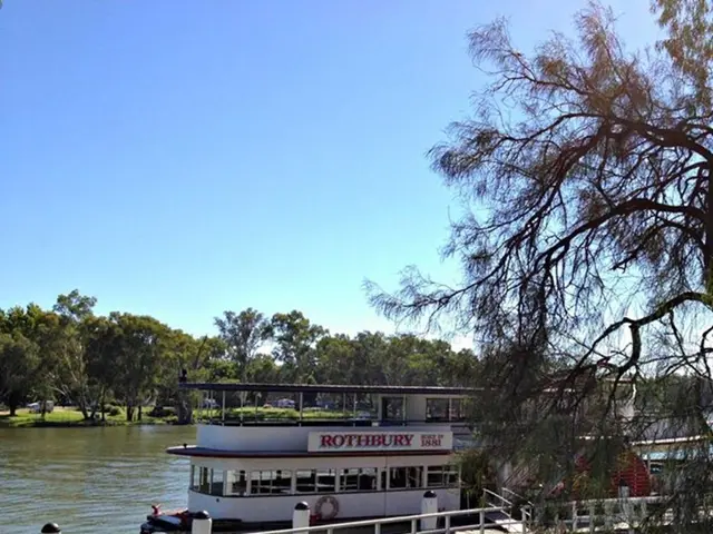 In the image, there is a boat house floating on the water surface and beside the boat house there...