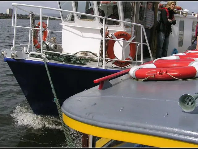 In this picture there are two boats which has few persons,ropes and some other objects on it is on...