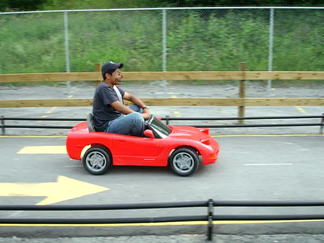 There is one man driving a small car on a road as we can see in the middle of this image , and...