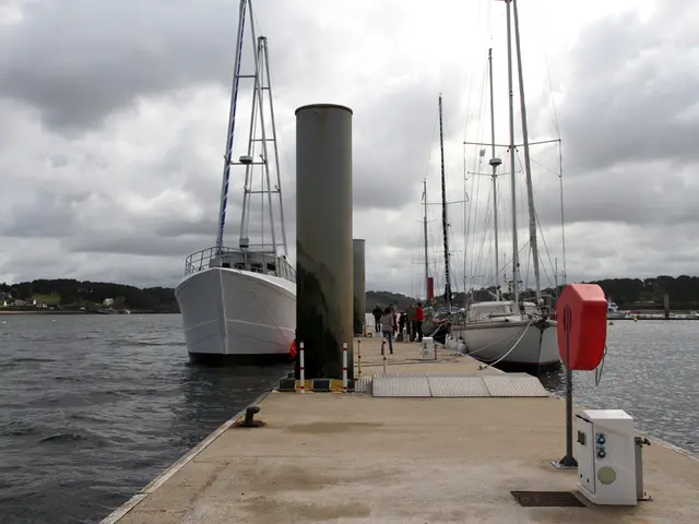In the center of the image there is a boardwalk and there are people. We can see ships on the...