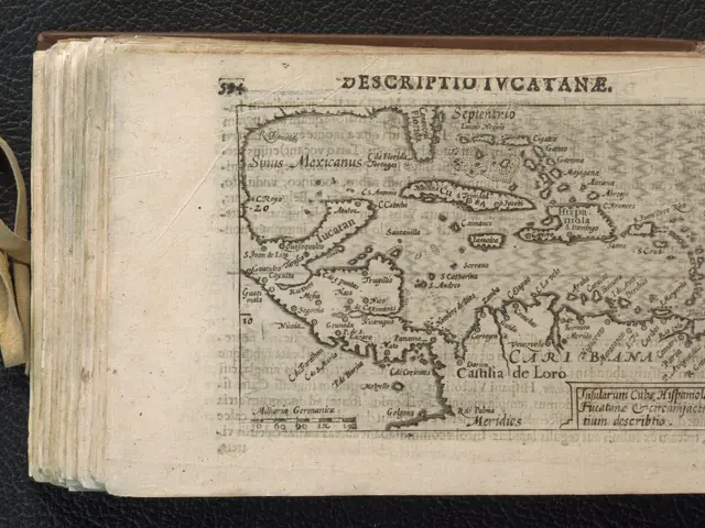 The image shows an open book with a map of the Caribbean on it, placed on a black surface. The map...