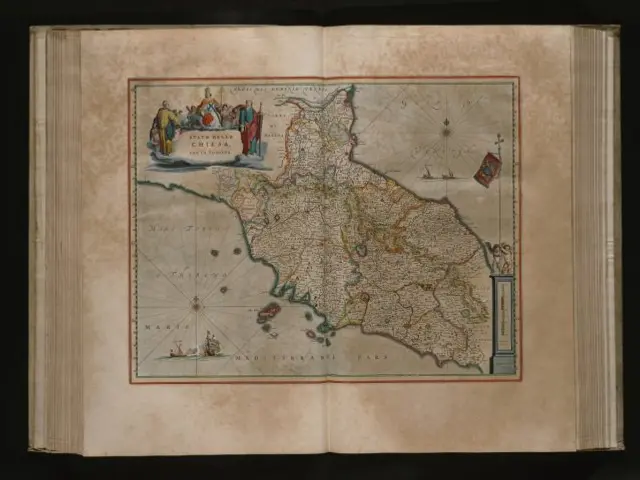 The image shows an open book with a map of Spain and Portugal on it, set against a dark background....