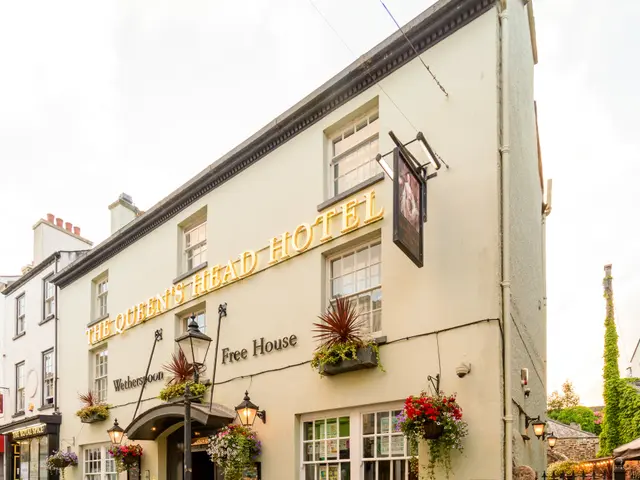 The image shows the Queen's Head Hotel in St Austell, Cornwall. It is a building with windows, a...