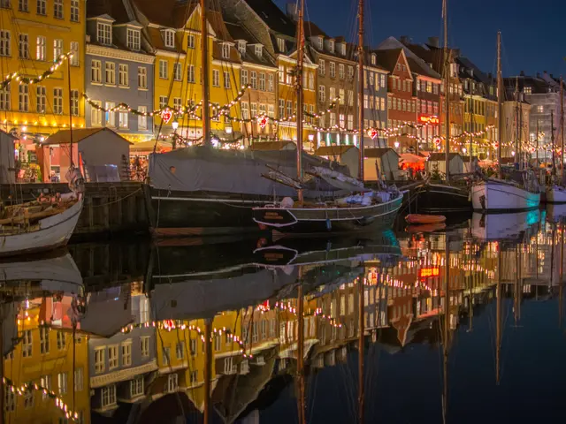 The image shows Nyhavn in Copenhagen, Denmark at night, with boats on the water, buildings with...