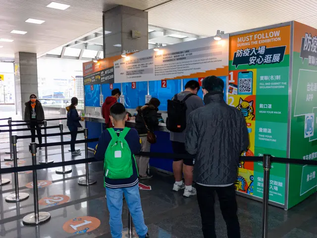 The image shows a group of people standing in line at an airport, wearing bags and surrounded by...