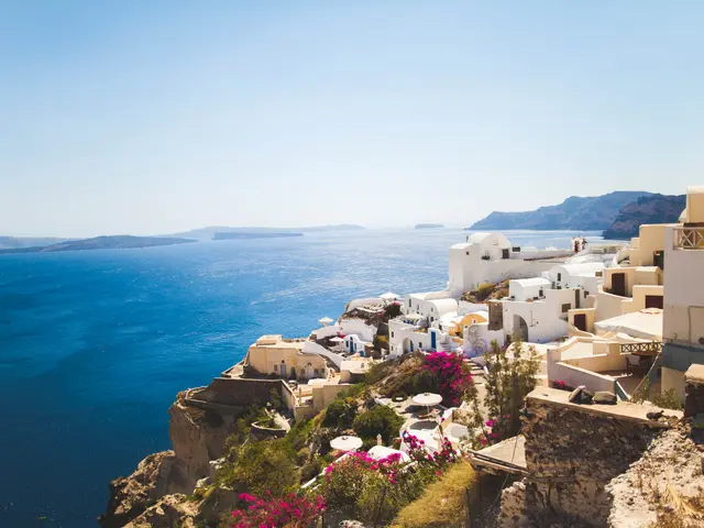 The image shows a stunning view of Santorini, Greece, with the crystal blue waters of the Aegean...
