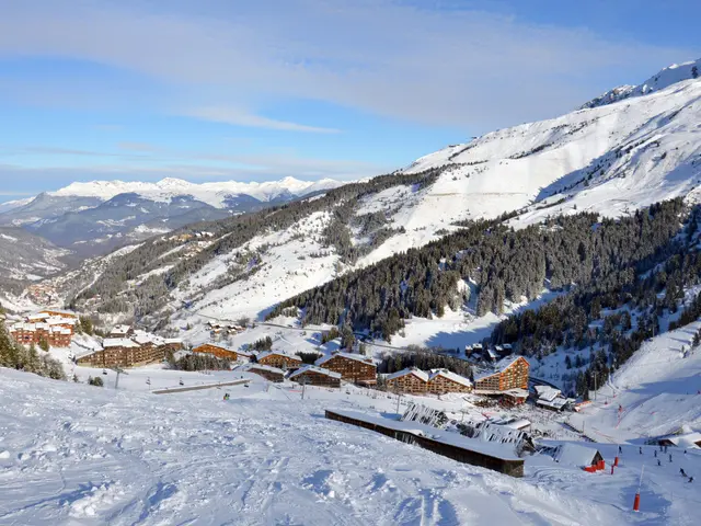 The image shows a picturesque view of a ski resort in the French Alps, with snow-covered mountains...