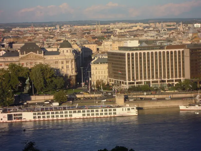 The image shows a river cruise ship traveling down the Danube River in Budapest, Hungary,...