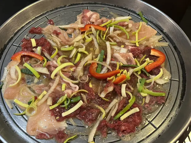 The image shows a large pot filled with a variety of food items on top of a stove, likely from a...