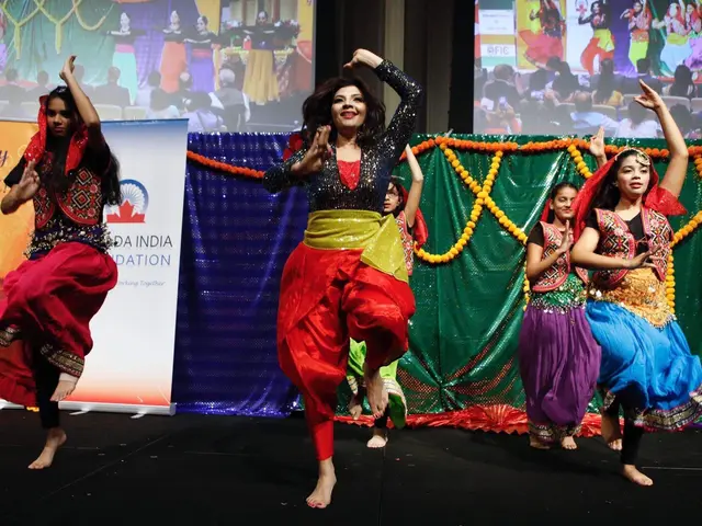 The image shows a group of young girls performing a traditional dance on a stage, surrounded by...