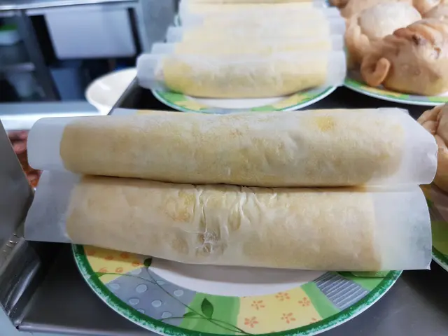 The image shows a table topped with plates filled with different types of food, including spring...