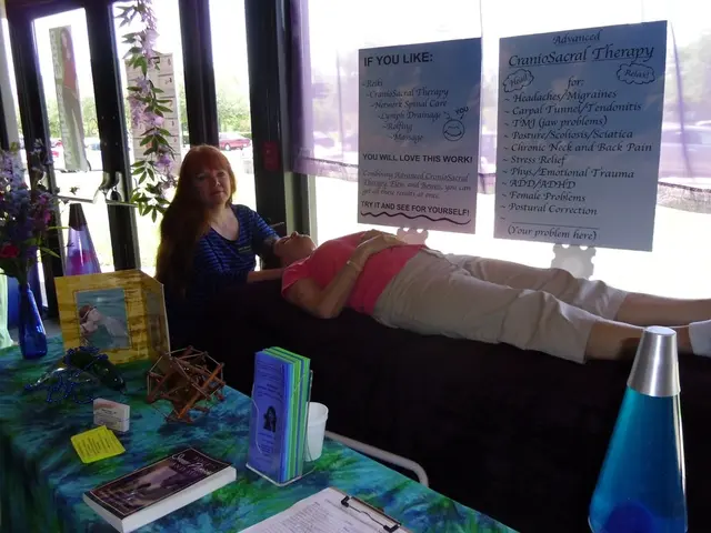 A woman is lying on a stretcher like thing. There is another woman doing a therapy. There are some...