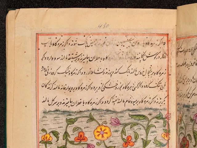 The image shows an open book with Arabic writing on it and a painting of flowers and leaves on the...