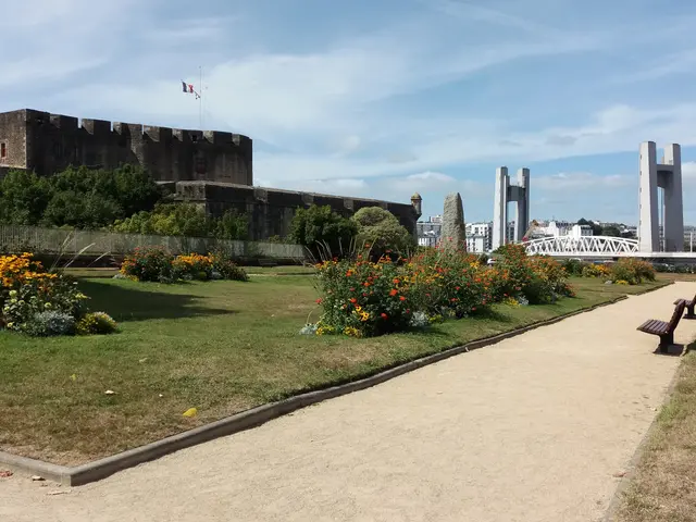 The image shows a park with benches and flowers in front of a castle, surrounded by grass, plants...
