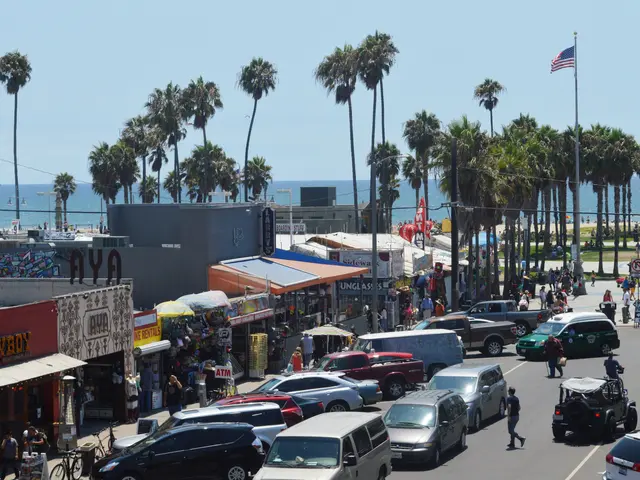 The image shows a bustling Santa Monica Pier in Santa Monica, California. There are many vehicles...