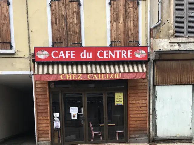 The image shows a building with a sign that reads "Cafe du Centre" on the side of it. There is a...
