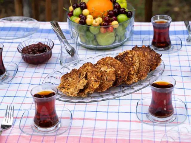 The image shows a table with a cloth draped over it, topped with plates of food and glasses of...